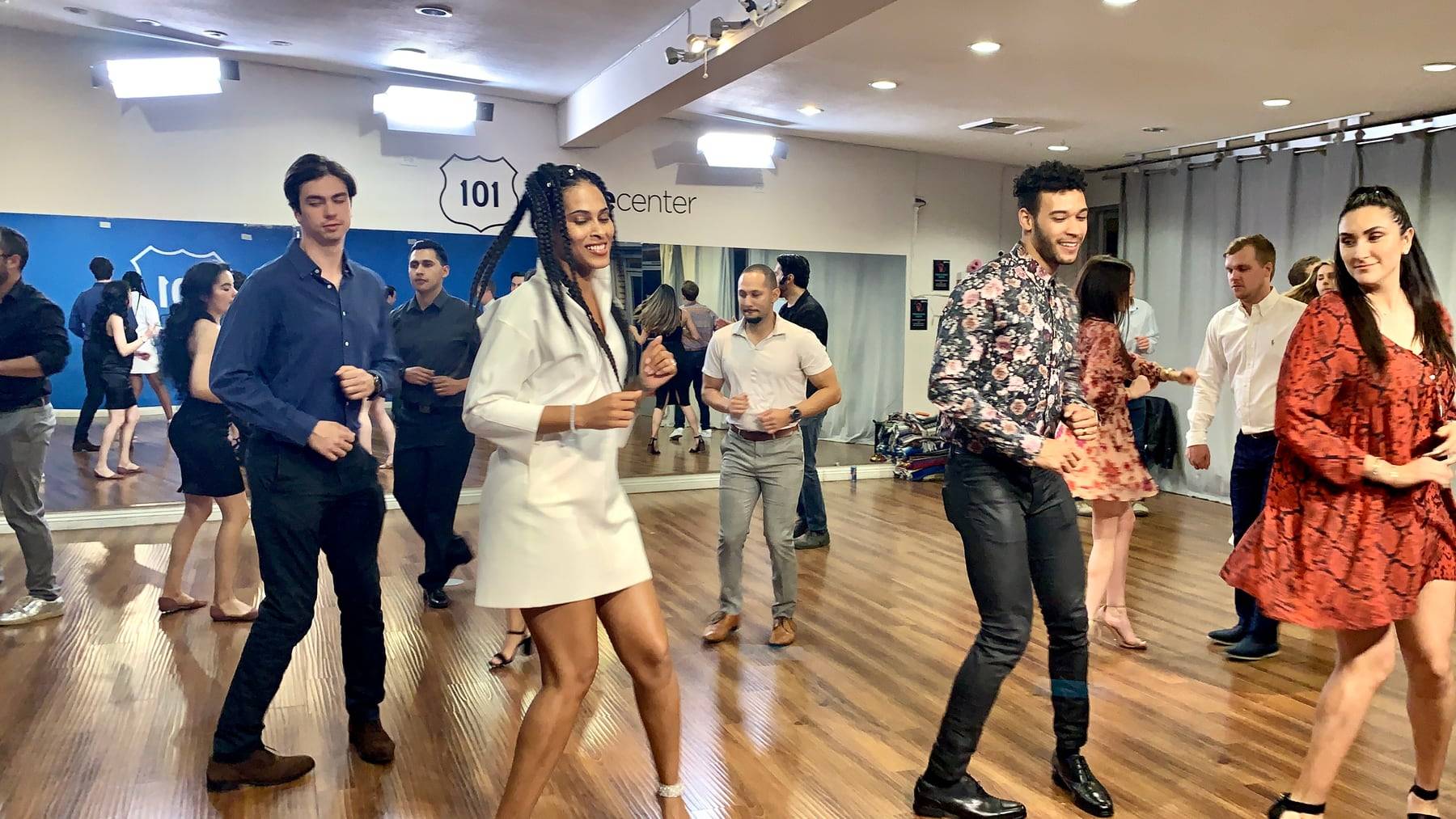 Students dancing salsa at a Salsa Dance LA group lesson in a bright Los Angeles partner studio